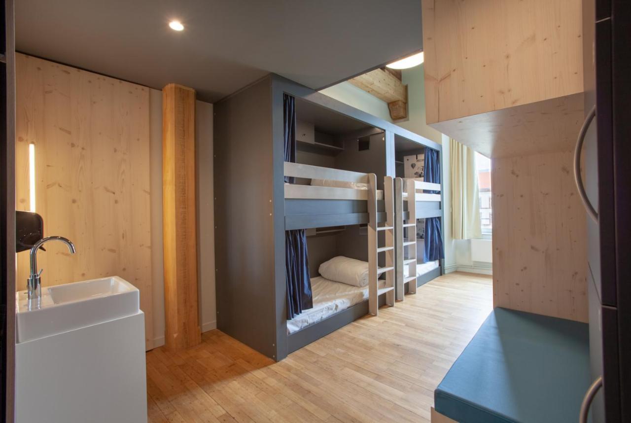 The People - Strasbourg Hostel Εξωτερικό φωτογραφία The photo shows a room designed for sleeping, featuring two sets of bunk beds made from light-colored wood. Each bunk has a curtain for privacy. The flooring is wooden, giving the space a warm feel. There's a small sink area visible, and the room is 