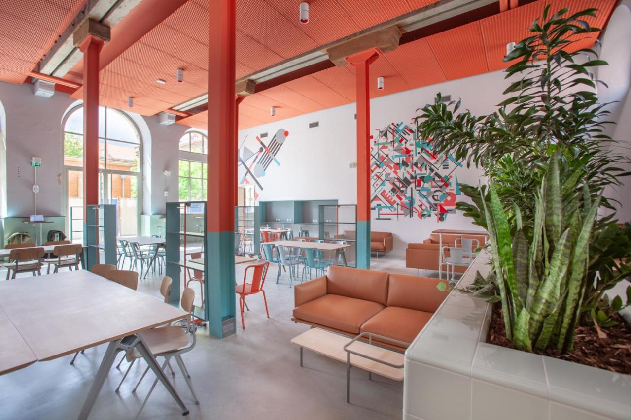 The People - Strasbourg Hostel Εξωτερικό φωτογραφία The photo showcases a modern interior of a café or a communal space. The design features a mix of seating arrangements, including a cozy brown sofa and various dining tables with colorful chairs. The space is well-lit, with large windows allowing nat