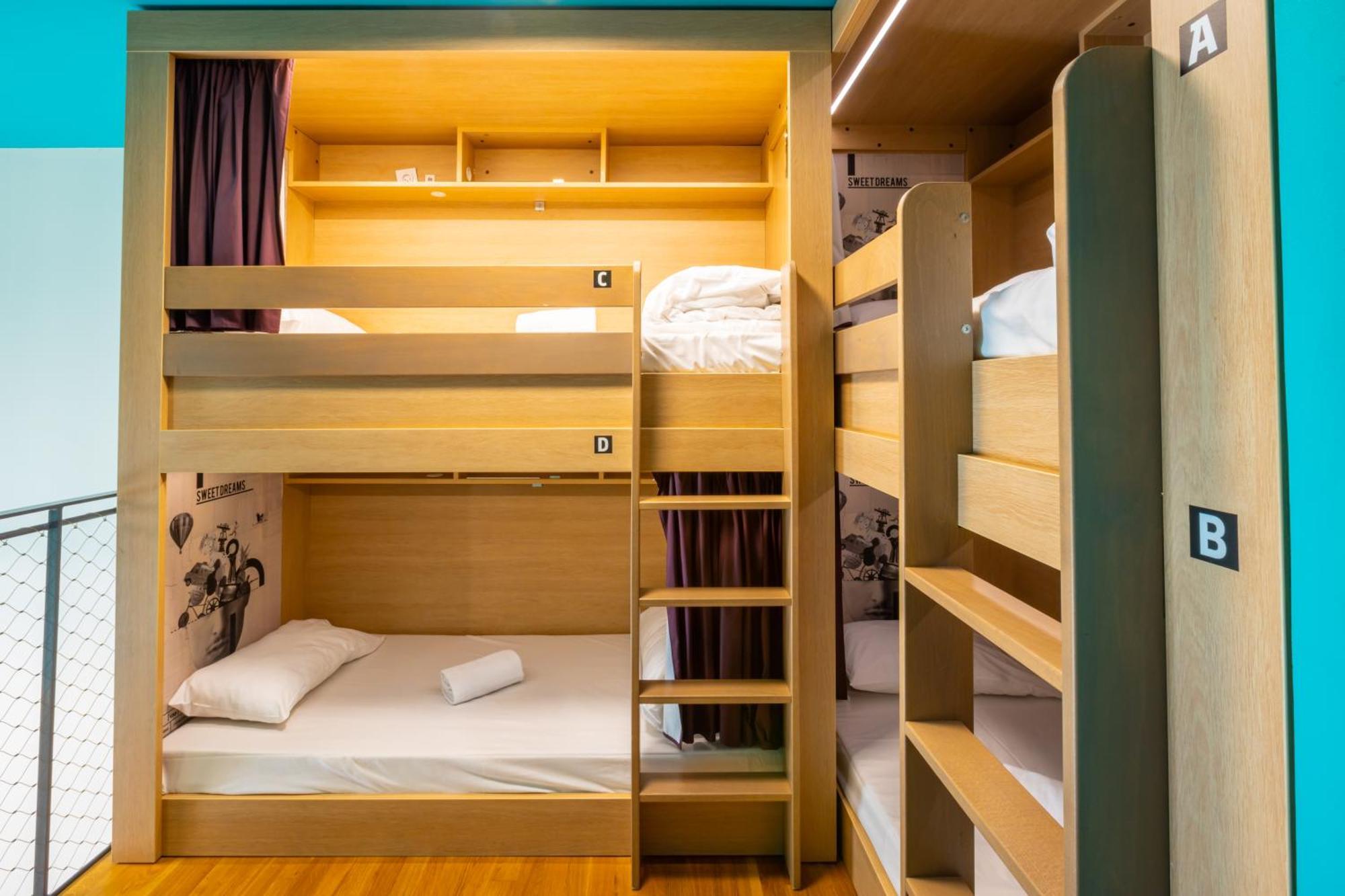 The People - Strasbourg Hostel Εξωτερικό φωτογραφία The photo shows a well-organized bunk bed setup in a room. There are two sets of bunk beds. The beds have wooden frames and are arranged with a lower and upper sleeping area. The upper bunk has a white mattress and bedding, while the lower bunk featu