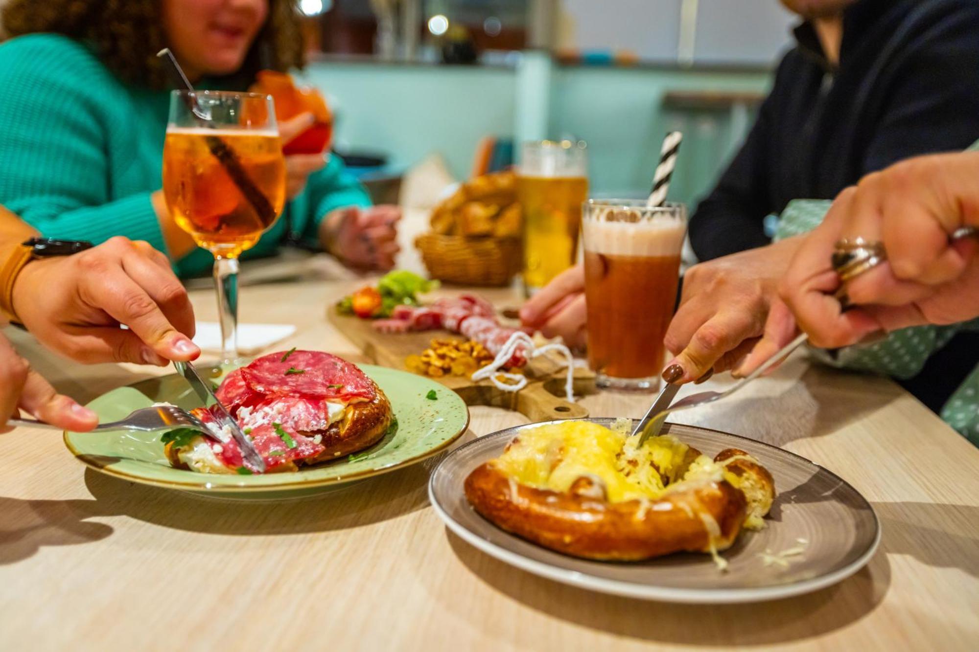 The People - Strasbourg Hostel Εξωτερικό φωτογραφία The photo features a table setting with several plates of food and drinks. In the foreground, there are two main dishes: one appears to be a savory pastry topped with ingredients like cheese and possibly meat, while the other has a colorful topping t